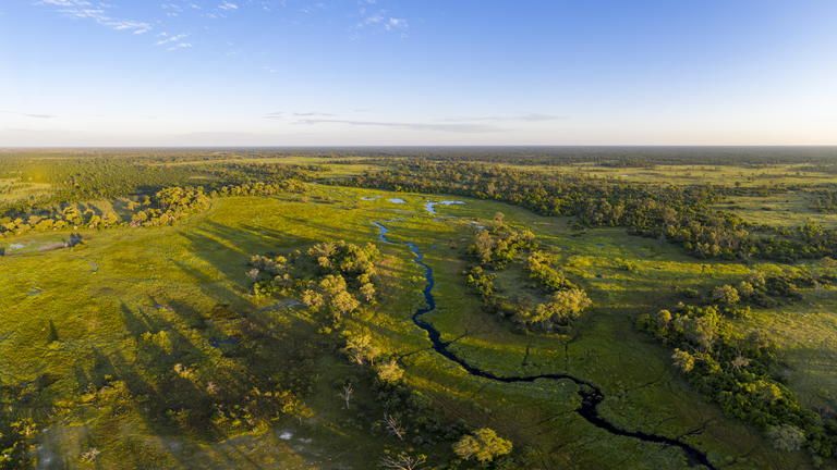 Aerial - Little Sable (left treeline) overlooking the floodplains of the Okavango Delta