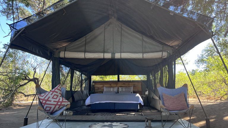 Harena River Camp tent - The main area offers dining or drinks in a lovely boma around the fire or dining at a new spectacular deck on the (sand) banks of the river. The elephants walk literally underneath you!