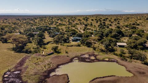 Porini Rhino Camp - Aerial view of the camp and watering hole
