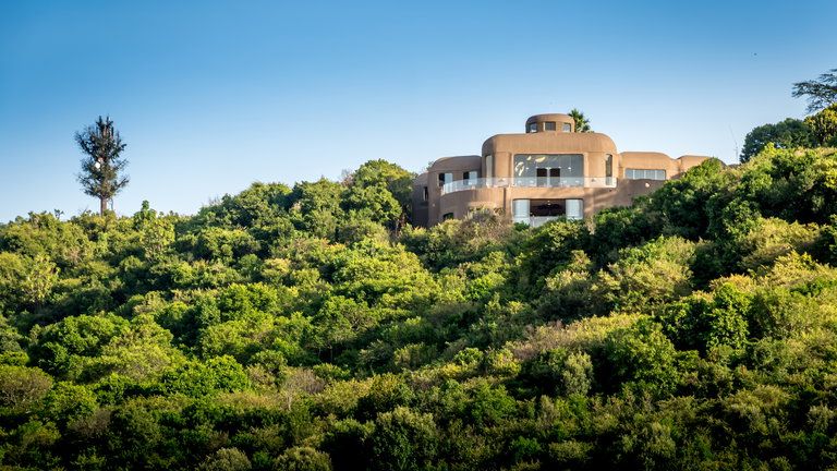 Exterior - The Mara Serena Safari Lodge's exterior is inspired by the traditional Maasai cultural motif of a cluster of domed, mud-colored huts encircled by a “Boma” of brushwood, blending raw African splendor with sumptuous sophistication. The lodge stands high on a bush-cloaked hill, offering panoramic vistas of the rolling grasslands and the dramatic wildlife arena of the Masai Mara National Reserve.